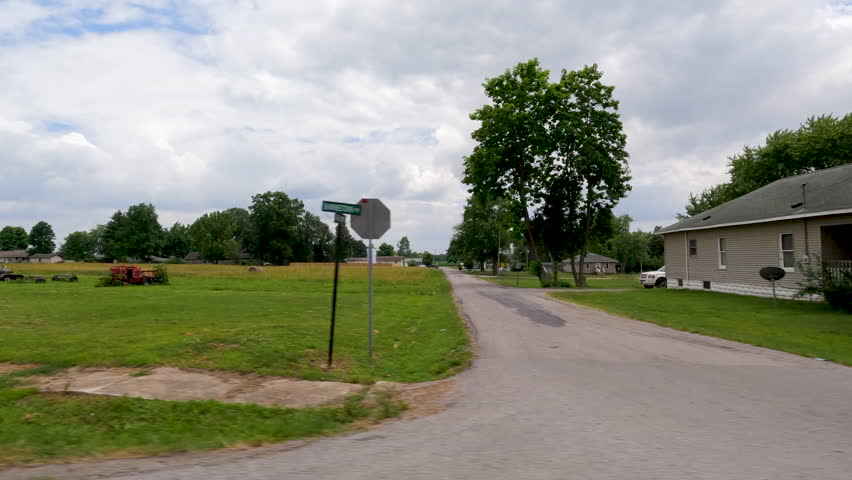 A glimpse into small town living. Traveling through rural, small town, USA with views of the simple life, big blue skies, farm land, homes, trailers and farm equipment. A rural slice of life.