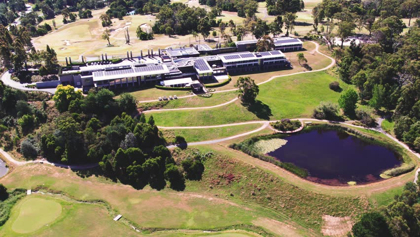 Aerial drone forward moving shot over wooden houses beside small lakes surrounded by lush green vegetation at daytime.