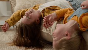 Two little funny carefree playful happy caucasian girls children kids sisters friends lie upside down in living room couch fooling around playing together having fun lying on sofa at home laughing - Powered by Shutterstock - Get 15% off with code: PIKWIZARD15