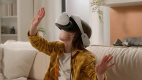 Funny caucasian kid girl child schoolgirl having fun in virtual reality headset at home couch playing online video game in world metaverse using innovative technology VR glasses exploring cyberspace - Powered by Shutterstock - Get 15% off with code: PIKWIZARD15