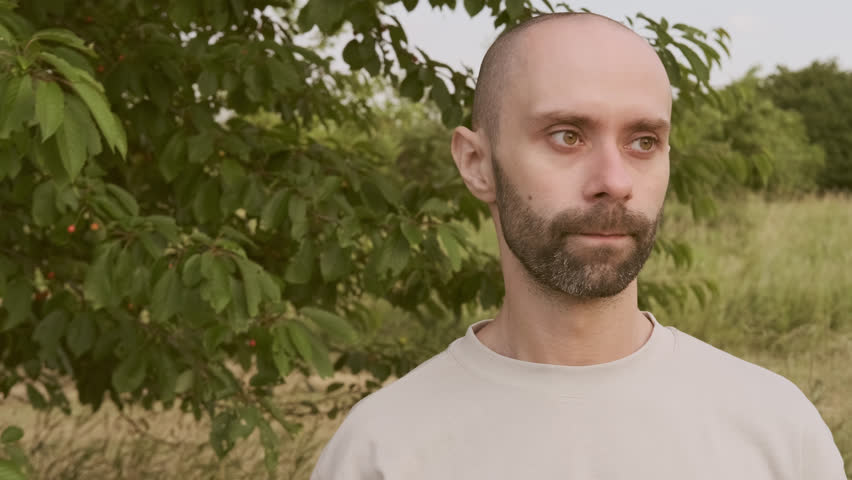 close-up male face, young man 30-35 years old puts on fashionable gold-rimmed glasses,, checks cleanliness and transparency of lenses, concept cleaning routine, lens protection, lens care essentials