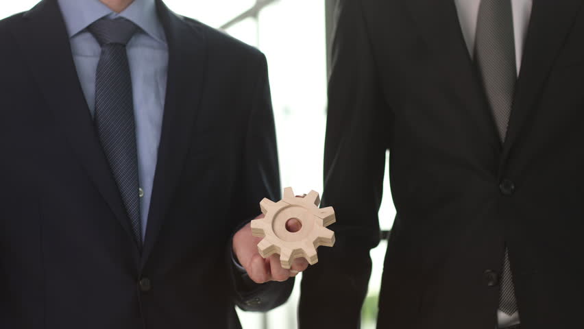 Close up hands holding round wooden figurines on the background of office worker. Royalty-Free Stock Footage #1105518303