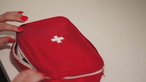 a caucasian woman takes out pills from a blister pack. a woman opens a first aid kit with pills. woman and first aid kit. close-up. slow motion video. High-quality shooting in Full HD - Powered by Shutterstock - Get 15% off with code: PIKWIZARD15