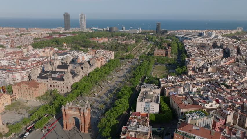 Aerial footage of public parks in urban borough. Arc de Triomf and Castell dels Tres Dragons historic landmark. Seaside in background. Barcelona, Spain