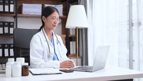 Attractive female doctor talking while explaining medical treatment to patient through a video call with laptop in hospital or clinic.
