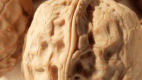 Macro video showcases the intricate patterns and textures of walnuts, revealing their rich brown hues and unique shell formations. Grain and food concept. Walnuts background. 4K HDR
