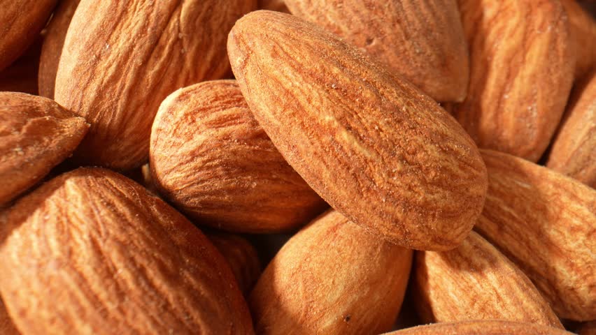 The macro video offers a visual exploration of almond kernels. It celebrates the natural elegance and complexity of these small, nutritious wonders. Food and snack concepts. Almond background. 4K
