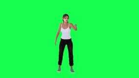 Young woman in white dress black pants and blue shoes painting on wall from front angle on green screen