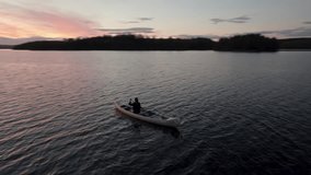 A serene video capturing a single person gracefully canoeing into the sunset.