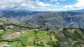 Aerial view of mountains, grasslands and road in the Andes, Andean or Sierra geographical region of the Peru that extends from north to south through the Cordillera de los andes