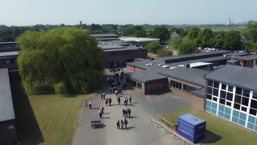 Drone shot 50fps, ND filter. Birds eye view of secondary, academy school playground. School children, school yard. Filmed East Yorkshire. UK. Royalty-Free Stock Footage #1105552601