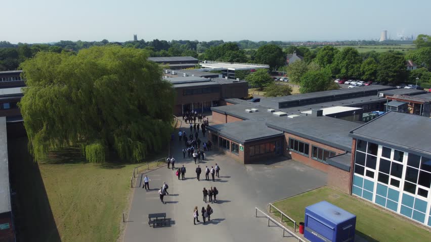 Drone shot 50fps, ND filter. Birds eye view of secondary, academy school playground. School children, school yard. Filmed East Yorkshire. UK. Royalty-Free Stock Footage #1105552601