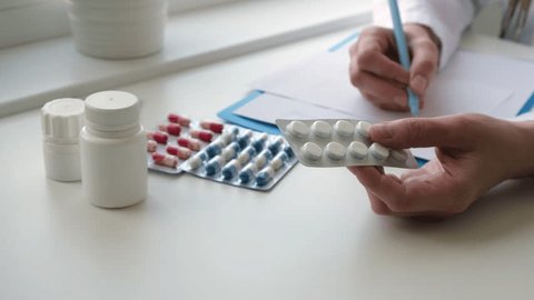 Doctor is pointing to drug tablets and giving medicine to female patient at office. Healthcare, medical and pharmacy industry concept Video stock