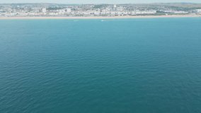 Aerial video of the Brighton coastline with blue water.