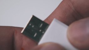 young man examines modern memory stick in white and orange case on light background extreme close view - Powered by Shutterstock - Get 15% off with code: PIKWIZARD15