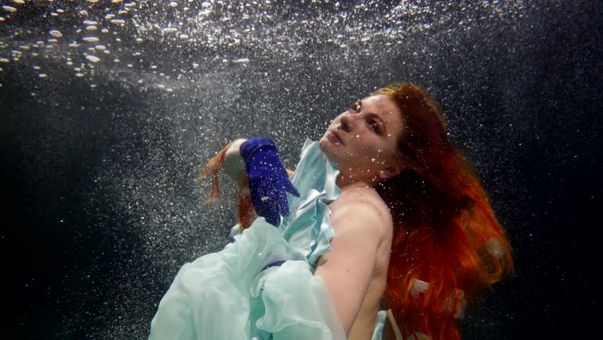 fabulous redhead mermaid floating under water surface, portrait of beauty woman with long red hair