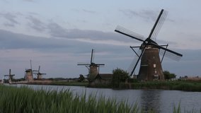 Beautiful wooden windmills at sunset in the Dutch village of Kinderdijk. Windmills run on the wind. The beautiful Dutch canals are filled with water. Beautiful sunset. - Powered by Shutterstock - Get 15% off with code: PIKWIZARD15