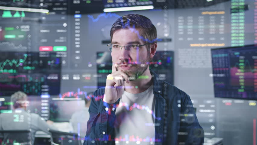 Male financial analyst works in broker agency office. 3D abstract AI graphics of real-time stocks, cryptocurrency charts on glass wall. VFX animation. Computers and big digital screens on background. Royalty-Free Stock Footage #1105568283