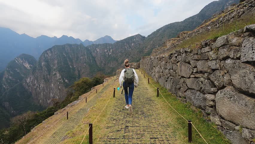 4k woman running and walking on lost city in Cusco, Machu Pichu city in Peru.
