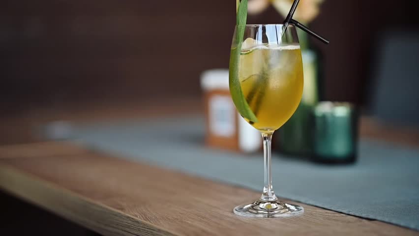 The bartender puts a beautiful refreshing cocktail on the table.
