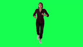 Woman running in a hurry in red dress black pants and white shoes from opposite angle on green screen