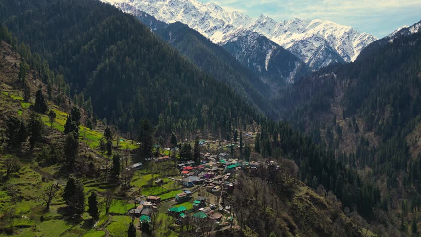 aerial view of Grahan Village - India's Most Beautiful and Hidden village at Himalayas mountains surrounded by snowy mountain - Kasol, India Royalty-Free Stock Footage #1105582955