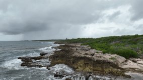 Ocean waves hit the rocks  on coastline in a cloudy weather. Wind before storm in the ocean
