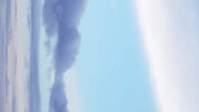 Time-lapse footage shows the gentle drifting of clouds in a blue sky. Vertical video. - Powered by Shutterstock - Get 15% off with code: PIKWIZARD15