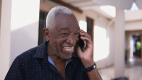 One happy black Brazilian senior man talking on phone outside. Friendly charismatic elderly person using modern technology conversing with smartphone device - Powered by Shutterstock - Get 15% off with code: PIKWIZARD15