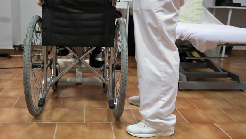Nurse touch shoulder of elderly patient woman in wheelchair supporting her showing empathy and compassion, caring about old people concept. High quality 4k footage | Shutterstock HD Video #1105590299
