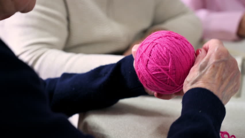 Close up of an old woman hands as she winds a woolen thread at nursing home. High quality 4k footage | Shutterstock HD Video #1105590301