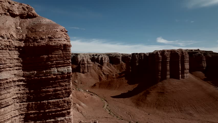 Flight by red sandstone cliffs to reveal the desert landscape