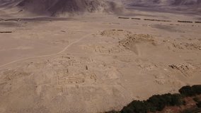 Aerial video of the ancient city of Caral. One of the oldest cities of the world. Drone orbits above the archaeological site. Located in the Supe valley in Lima, Peru. Recorded in 4k quality.