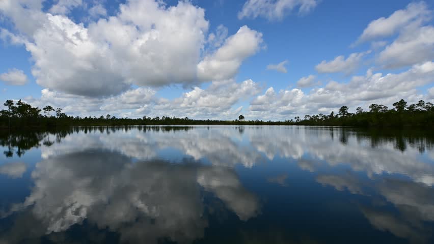 Time lapse of active sunny summer cloudscape over Pine Glades Lake in Everglades National Park, Florida 4K.