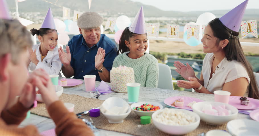 Celebration, family and girl in park for birthday, cheering and party event outdoors for social gathering. Food, lunch and mother, grandfather and children at picnic with cake, presents and singing