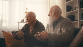 Excited senior male friends playing video game using joysticks, hanging out