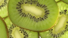 Close up of sliced kiwi fruit on white background. Rotating and dolly video of kiwi. It have juice rich in vitamins and energy. Fresh fruits concept.