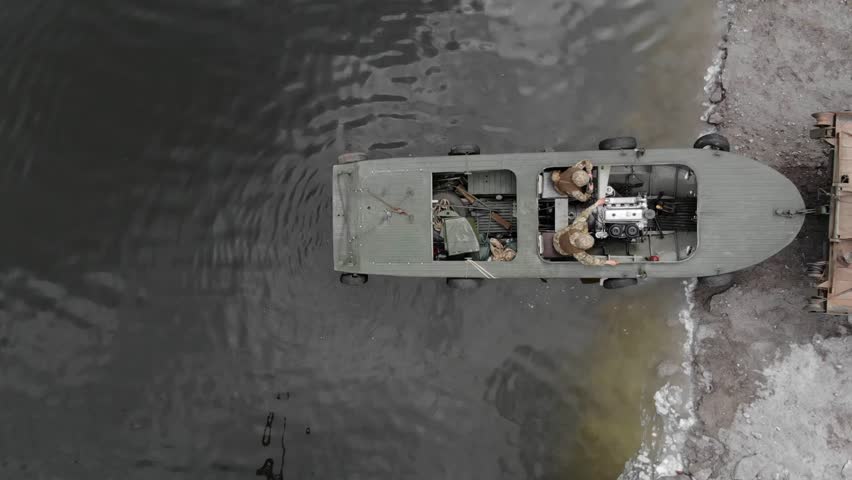 Pontoon bridge of the Ukrainian army. Installation of a temporary crossing near the destroyed bridge. Soldiers collect pontoon ferry. Top view from a drone. 