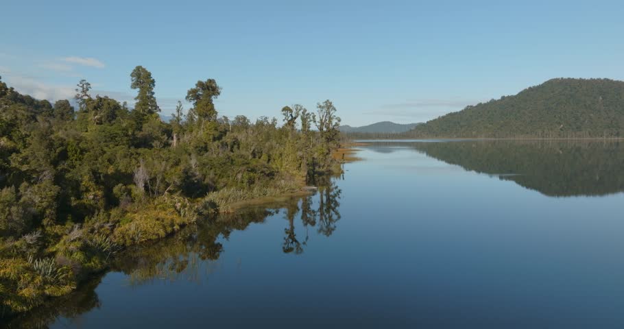 Aerial: Native forest and calm lake on the west coast of the South Island. Lake lanthe, New Zealand 