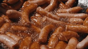 Close up video of preparing fried sausages outdoors in frying pan