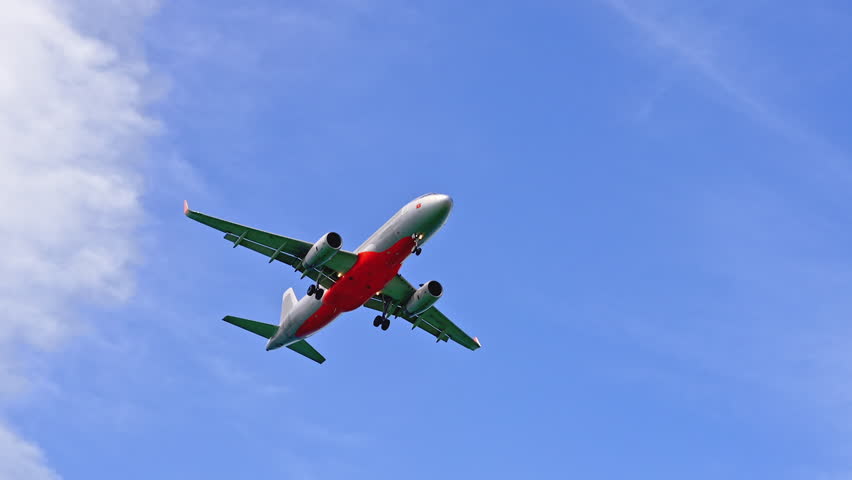 A Large Airliner With Passengers is Landing. Go Everywhere. Plane Flies in the Sky at Sunny Day