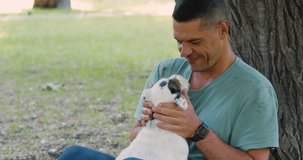 Man and his best friend. Love to pets as a way to mental health. A middle-aged man plays with his Jack Russell Terrier dog outdoor. Zoom out 4k video.
