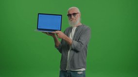 Green Screen.Portrait of an Old Man in the Funny Glasses with a Laptop with Blue Screen Shows Thumb Up. Artificial Intelligence and Machine Learning for Seniors.