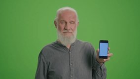 Green Screen. Portrait of a Smiling Old Man with a Smartphone with Blue Screen and BTC Coin.Achievement Career Wealth, Cryptocurrency Investment, Mining.Bitcoin and the Future of Accumulated Pensions.