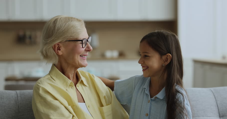 Loving elderly 60s grandma cuddles tightly her little grandkid, look affectionate, feel happy enjoy priceless time together. Understanding between two generation relatives people, family bond and love Royalty-Free Stock Footage #1105653611