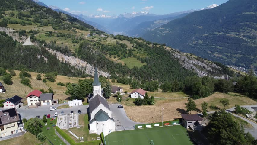 idyllic church in green mountain landscape in valais in switzerland, perfect sunny weather