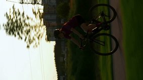 Woman cycling. Professional road cyclist training on bicycle, doing fitness exercises. Vertical video. Sport activity. Active healthy lifestyle. Cardio workout training. Sport motivation