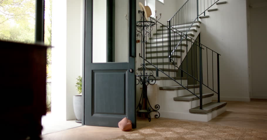 General view of staircase at home with open front door, slow motion. Home, interior decor, architecture and domestic life, unaltered.