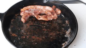 Adding sunny side eggs to fried bacon in cast iron skillet. Traditional breakfast - Powered by Shutterstock - Get 15% off with code: PIKWIZARD15