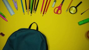 Colorful school supplies moving to green backpack on yellow background. Back to school concept. Stop motion - Powered by Shutterstock - Get 15% off with code: PIKWIZARD15